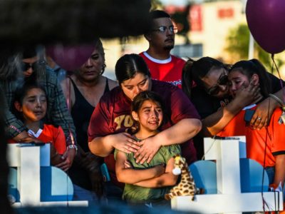 Gabriella Uriegas, a soccer teammate of Tess Mata who died in the shooting, cries while her mother Geneva Uriegas holds her as they visit a makeshift memorial outside the Uvalde County Courthouse in Texas on May 26, 2022. (Chandan Khannah, AFP, Getty Images)
