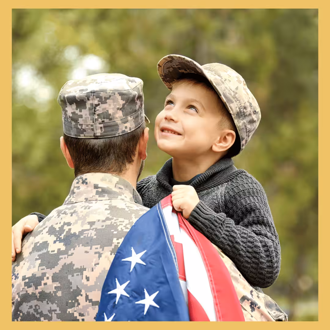 A young child being held by his US Armed Forces father. 
